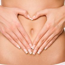 hands held in heart shape over belly button