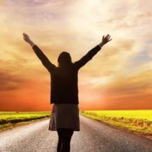 woman standing in road with arms thrown out