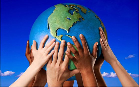 Lots of different hands holding up a globe of Earth