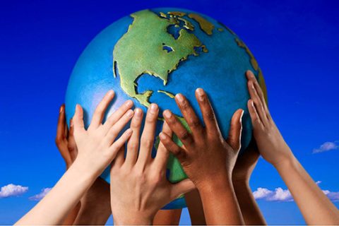 Lots of different hands holding up a globe of Earth
