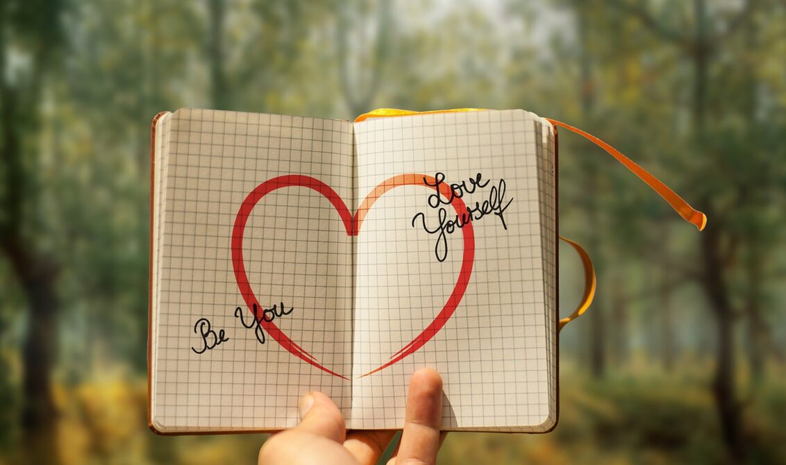 Journal with self-love reminders written on it