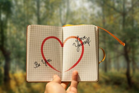 Journal with self-love reminders written on it